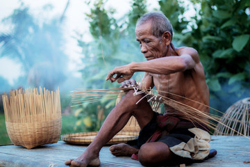 Old man are weaving in countryside.