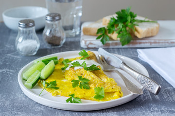 Omelette with parsley, served with sour cream and fresh cucumber.