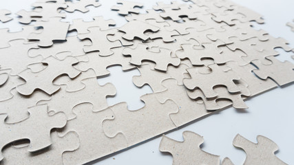 Hand put missing jigsaw puzzle into the paper board