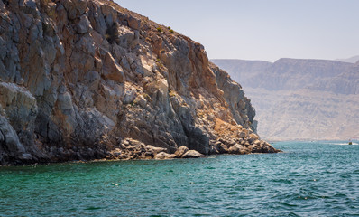Fototapeta na wymiar Beautiful coastal scenery near Khasab, in Musandam peninsula, Oman, photo taken from a boat during a tour.