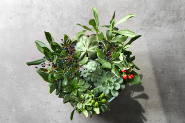 Creative flower bouquet with succulents as gift on light background
