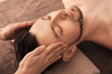 Young man receiving massage at spa salon
