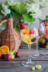 Homemade refreshing fruit sangria or punch with champagne, strawberries, oranges and grapes.