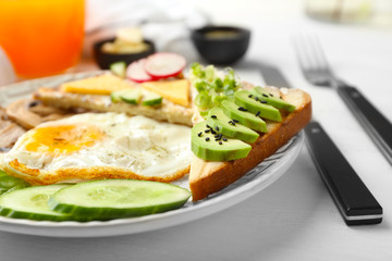 Delicious toast with vegetables and fried egg on plate, closeup