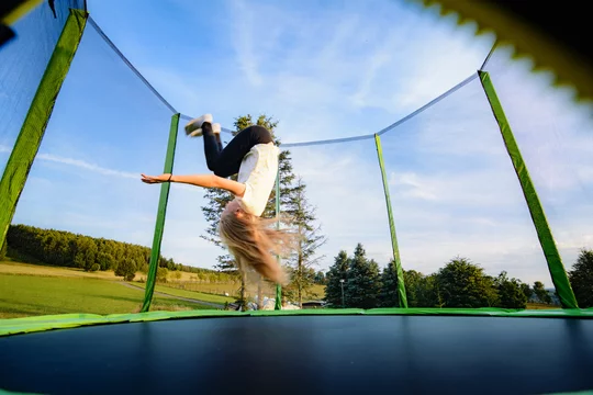Kind auf Trampolin - Salto rückwärts dynamisch Photos | Adobe Stock