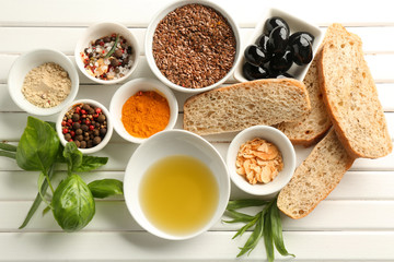 Composition with olive oil, spices and bread on wooden table