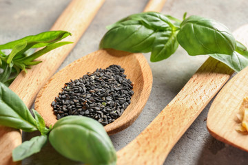 Wooden spoon with black sesame seeds on table