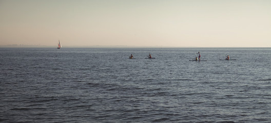 Sea. Swimming men and women on kayaks.