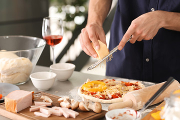 Obraz na płótnie Canvas Young man preparing pizza in kitchen