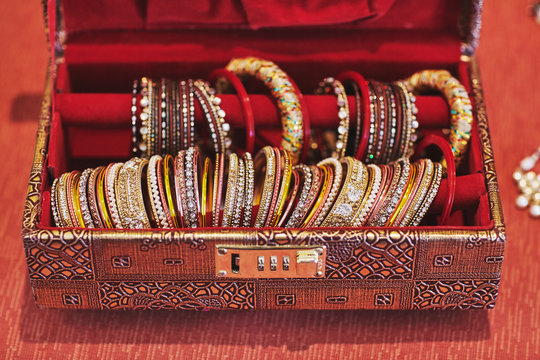 A Red Box With Collection Of Glitter Bracelets Or Bangle For Indian Bride