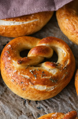 Traditional salted pretzels with oregano over wooden background. Oktoberfest or beer snack concept.