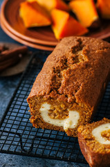 Freshly baked pumpkin pound cake with cream cheese filling served on a wire rack