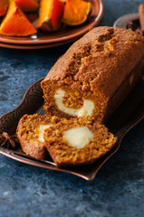 Freshly baked pumpkin pound cake with cream cheese filling served on a wire rack