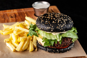 Vegetarian black burger with cutlet peas falafel, tomato, cucumber, rucola salad and French fries....