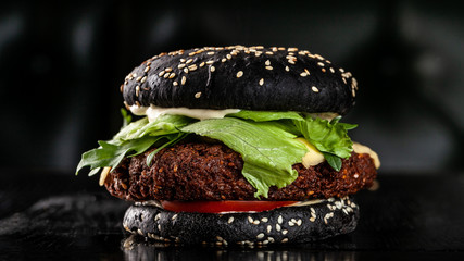 Vegetarian black burger with cutlet peas falafel, tomato, cucumber, rucola salad and French fries....