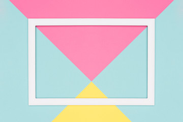 Abstract geometrical pastel blue, pink and yellow paper flat lay background. Minimalism, geometry and symmetry template with empty picture frame mock up.