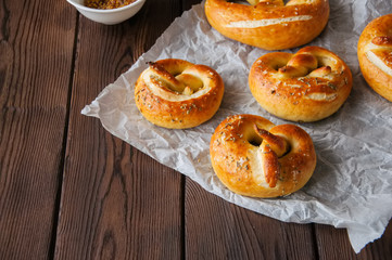 Traditional salted pretzels with oregano over wooden background. Oktoberfest or beer snack concept.