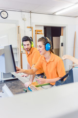 Obraz premium Carpenter programming computer controlled saw, a CNC machine