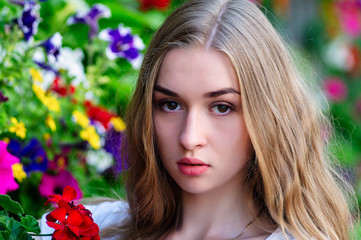Naklejka premium Fashion model on the background of flowers.