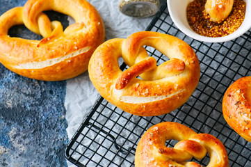 Traditional salted pretzels with oregano over blue stone background. Oktoberfest or beer snack concept.