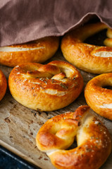 Traditional salted pretzels with oregano over wooden background. Oktoberfest or beer snack concept.