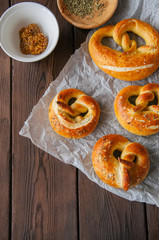 Traditional salted pretzels with oregano over wooden background. Oktoberfest or beer snack concept.