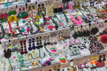 Many different various woman jewellery and accessory on display: bracelets, earing, necklaces, rings