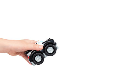 Black toy police car with kid hand, isolated on white background. copy space template