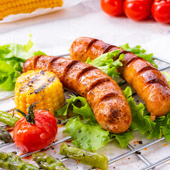 grilled tasty krakauer sausage with boiled corn and green salad
