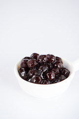 black pearls. Boiled tapioca pearls for bubble tea on white background. Copy space