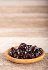 Tapioca Pearl , Bubble topping for tea or other beverage, in a cup, place on wooden table. Copy space