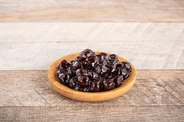 Tapioca Pearl , Bubble topping for tea or other beverage, in a cup, place on wooden table. Copy space