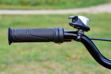 Kids yellow bicycle in park, close up parts, rudder with brakes and bell