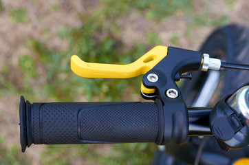 Kids yellow bicycle in park, close up parts, rudder with brakes