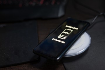 Touchscreen smartphone wireless charging on induction charger. © Daniel Jędzura