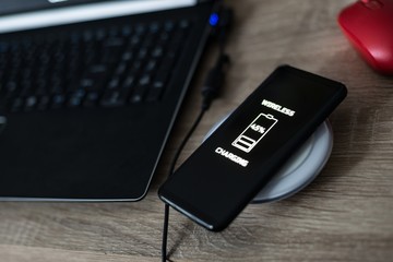 Cellphone wireless charging on induction charger. © Daniel Jędzura