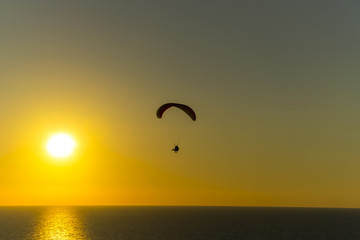 Fototapeta na wymiar paragliding at sunset