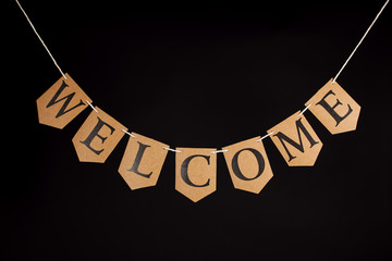 Welcome home banner. Greeting with the word welcome written in letters hanging on a bunting string....