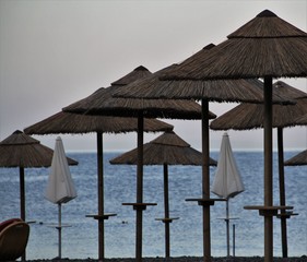 parasol en paille sur une plage des éoliennes
