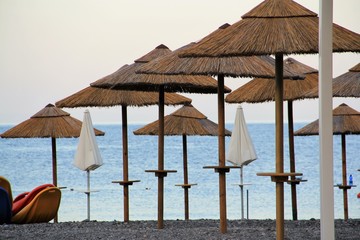 parasol en paille sur une plage des éoliennes