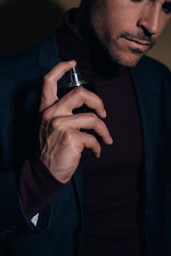 Young business man applying perfume