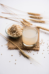 Barley water in glass with raw and cooked pearl barley wheat/seeds. selective focus