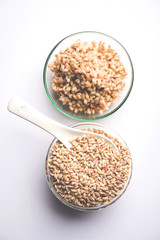 Raw and cooked Barley pearl seeds in a bowl or over white plate. selective focus