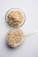 Raw and cooked Barley pearl seeds in a bowl or over white plate. selective focus