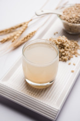 Barley water in glass with raw and cooked pearl barley wheat/seeds. selective focus
