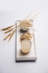 Barley water in glass with raw and cooked pearl barley wheat/seeds. selective focus