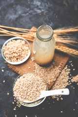 Barley water in glass bottle with raw and cooked pearl barley wheat/seeds. selective focus
