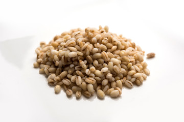 Raw and cooked Barley pearl seeds in a bowl or over white plate. selective focus