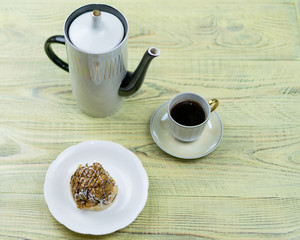 Coffee in a retro cup and cake on a wooden background.