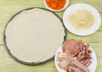 Fresh raw Italian pizza during cooking. Ingredients for pizza.